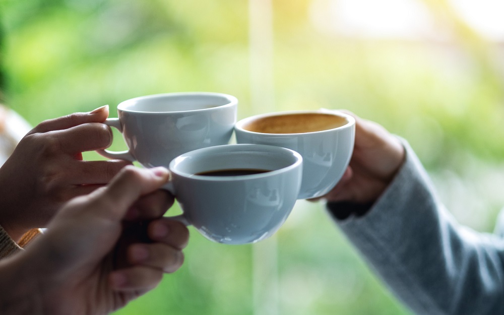 A group of young people enjoyed drinking and clinking coffee cups together