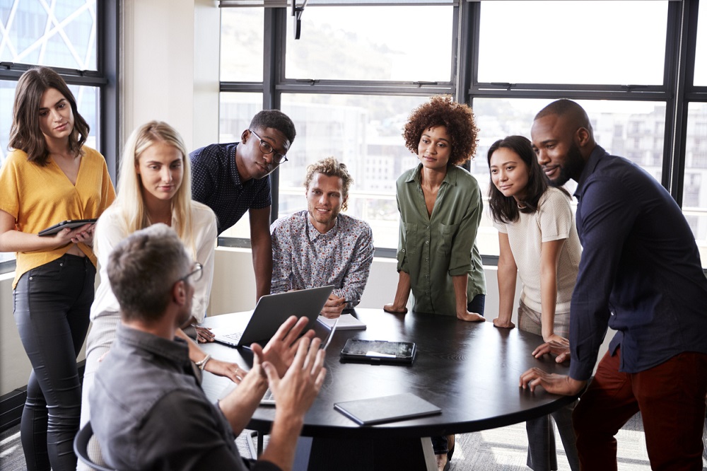 Creative business team listening to colleague at a brainstorm meeting
