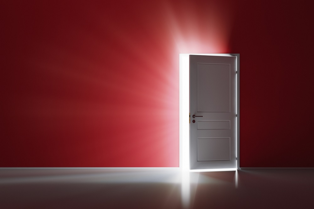 Open white door on red wall